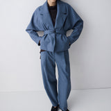 Person wearing a blue suit against a white background