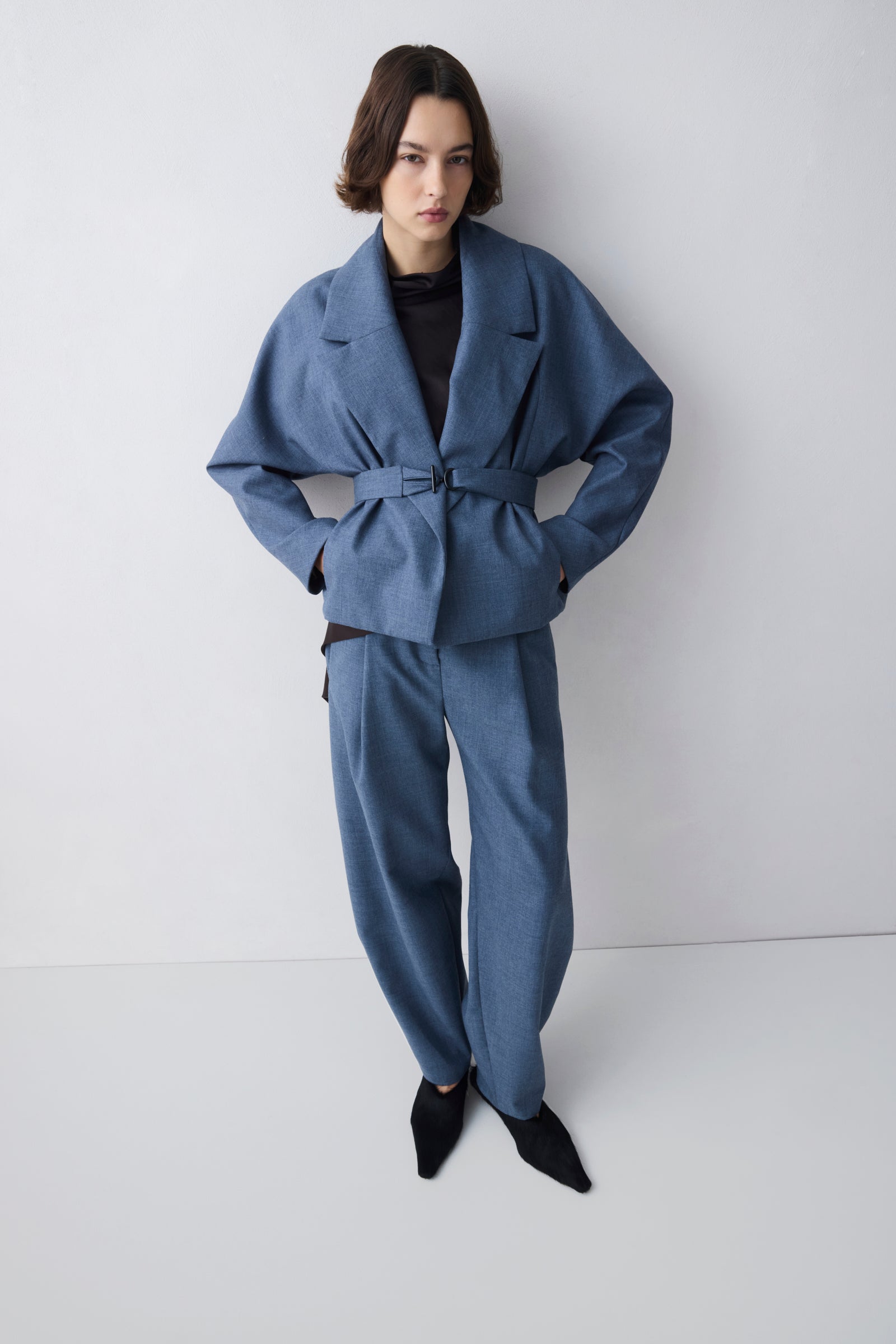 Person wearing a blue suit against a white background