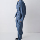 Person wearing a blue outfit with a belt on a white background
